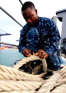 US Navy 111203-N-WJ771-079 Seaman Apprentice Luis Silva repairs a Kevlar mooring line on the forecastle of the forward-deployed amphibious dock lan photo