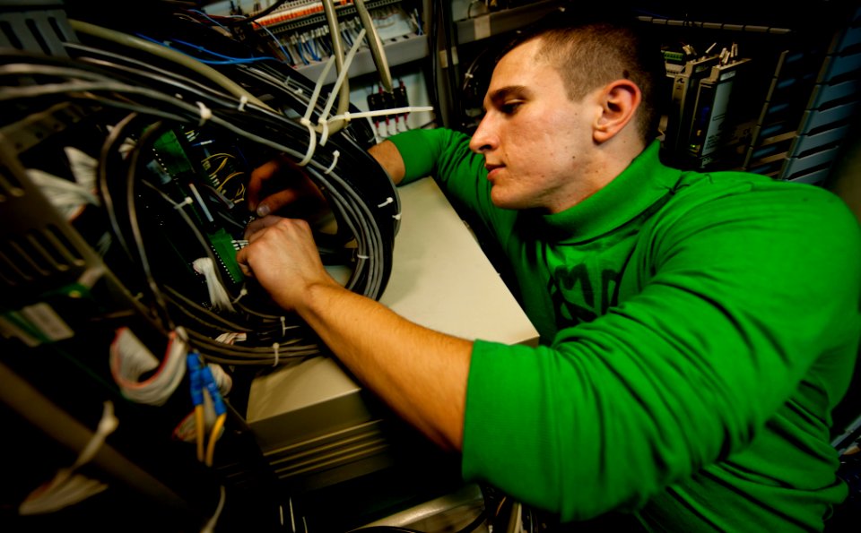 US Navy 111201-N-OY799-022 Aviation Electrician's Mate Airman Zachary King installs wiring aboard the Nimitz-class aircraft carrier USS John C. Ste