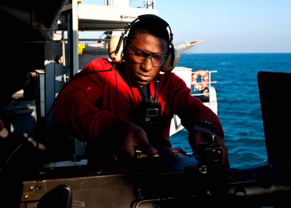 US Navy 111207-N-BT887-244 Aviation Ordnanceman Airman Robert Ware loads a .50-caliber machine gun during a live-fire exercise aboard the Nimitz-cl