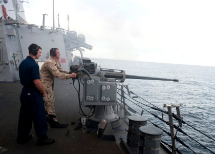 US Navy 111206-N-FI736-128 Sonar Technician (Surface) 2nd Class Gareth Erasmus, right, and Gunner's Mate 2nd Class Justin McKay fire a Mk 38 25mm m