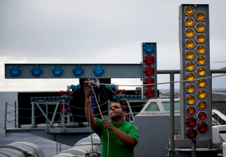 US Navy 111206-N-DR144-779 Interior Communications Electrician 3rd Class Emmanuel Camilo practices rigging the manually operated visual landing aid
