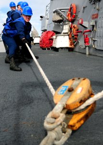 US Navy 111206-N-ZF681-449 Sailors heave a fuel line aboard the guided-missile destroyer USS Halsey (DDG 97) during a replenishment at sea photo