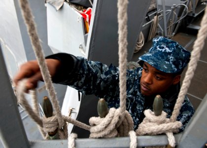 US Navy 111205-N-FI736-072 Quartermaster Seaman James Johnson secures nylon lines aboard the Arleigh Burke-class guided-missile destroyer USS Porte