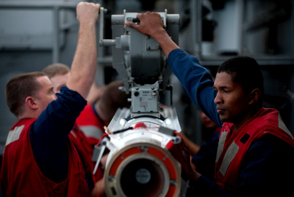 US Navy 111206-N-DR144-375 Fire Controlman 2nd Class Jefferson Daniels and other Sailors load a RIM-162D Evolved Sea Sparrow missile into its launc