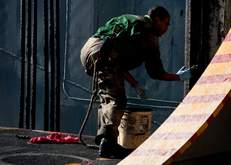 US Navy 111207-N-BT887-049 Machinist's Mate Fireman Damien Robinson, from St. Louis, applies grease to an aircraft elevator aboard the Nimitz-class