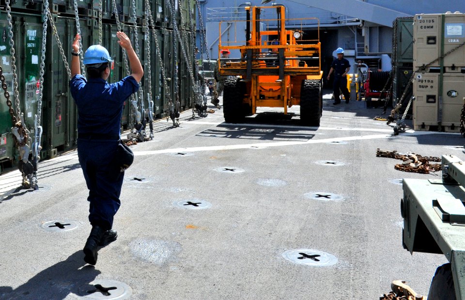 US Navy 111203-N-KS651-020 A Sailor directs a forklift aboard the amphibious dock landing ship USS Pearl Harbor (LSD 52) during a port visit in Gua