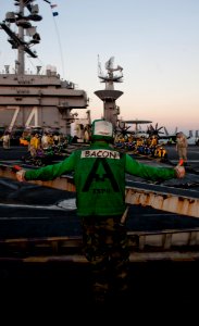 US Navy 111207-N-OY799-465 Aviation Boatswain's Mate (Equipment) 2nd Class Justin Akins signals for Sailors to set up the barricade during drills o
