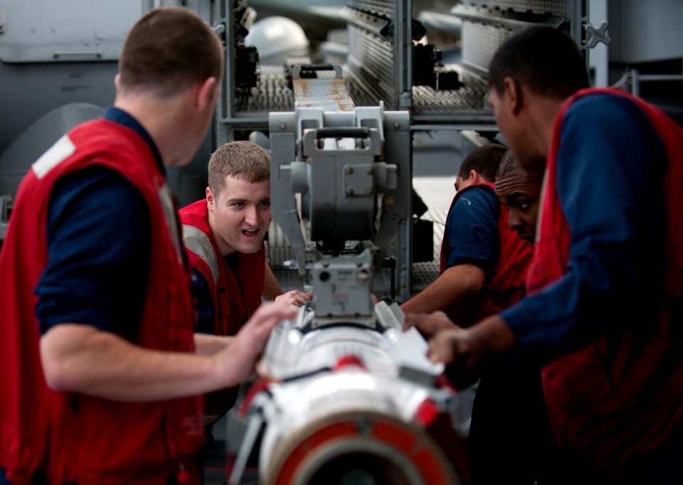 US Navy 111206-N-DR144-344 Fire Controlman 2nd Class Joseph Marsac and other Sailors load a RIM-162D Evolved Sea Sparrow missile into its launcher