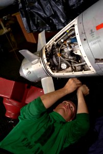 US Navy 111205-N-GC412-048 Aviation Structural Mechanic 3rd Class Allen Dedon removes a stripped screw from an aerial refueling store aboard the Ni