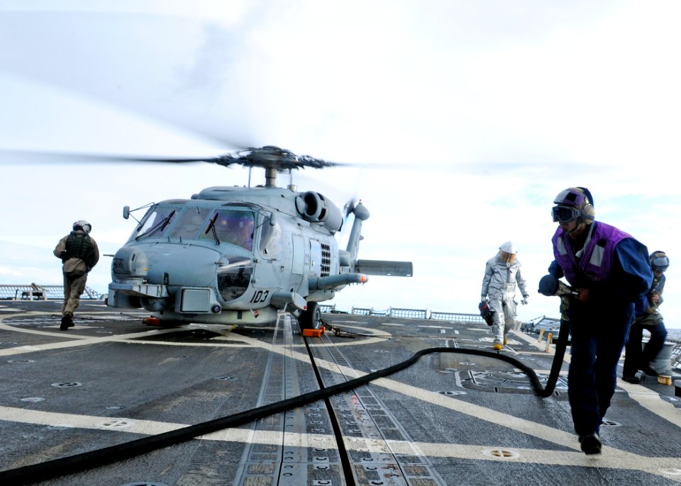 US Navy 111206-N-ZF681-254 Gas Turbine System Technician Mechanical Fireman Matthew Horn moves a fuel line away from an SH-60B Sea Hawk helicopter