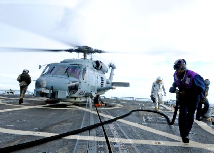 US Navy 111206-N-ZF681-254 Gas Turbine System Technician Mechanical Fireman Matthew Horn moves a fuel line away from an SH-60B Sea Hawk helicopter