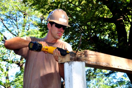 US Navy 111206-A-TF780-032 Builder 2nd Class Nicholas Fox removes rebar from a wooden beam at Centro Escolar Elementary School. NMCB-23 will comple photo
