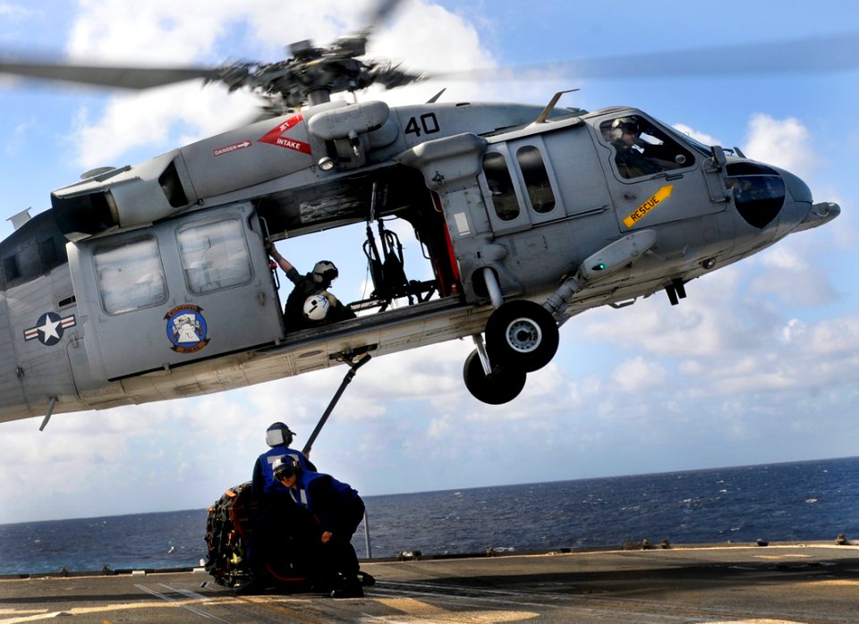 US Navy 111208-N-BC134-131 Sailors aboard the guided-missile cruiser USS Bunker Hill (CG 52) connect a cargo pendant on an MH-60 Sea Hawk helicopte