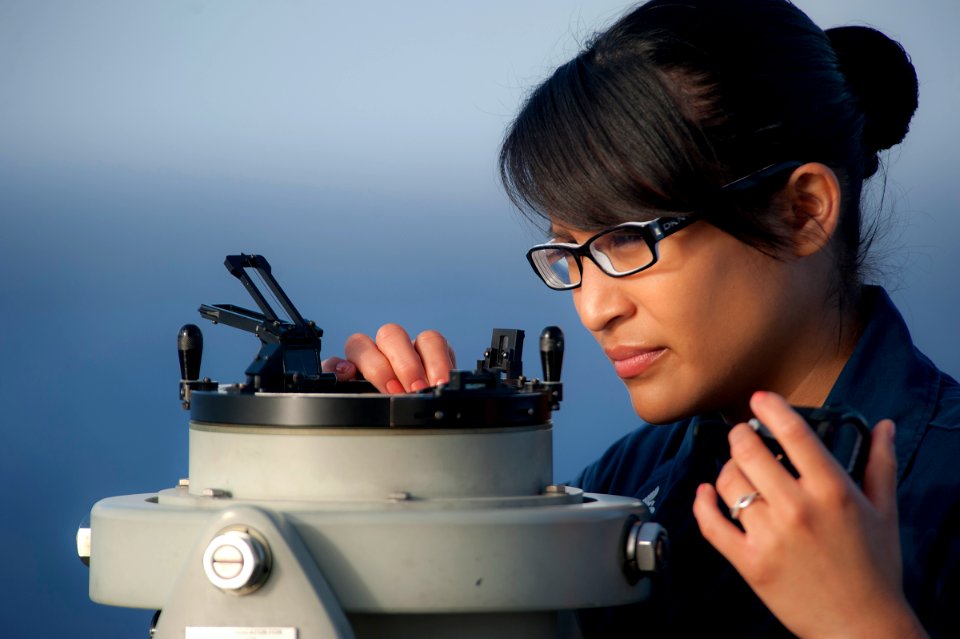 US Navy 111203-N-DX615-076 Quartermaster 3rd Class Loren Lopez looks through an azimuth ring aboard the amphibious assault ship USS Makin Island (L