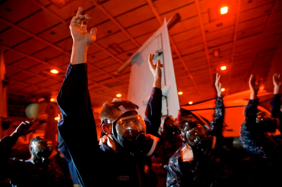 US Navy 111207-N-DR144-254 Aviation Maintenance Administrationman Airman Robert Sasser and other Sailors raise their hands as they finish donning t