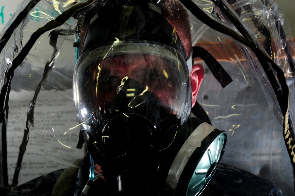 US Navy 111207-N-RG587-004 Mass Communication Specialist 2nd Class Benjamin Stevens wears a joint service mask leakage detector canopy to test the