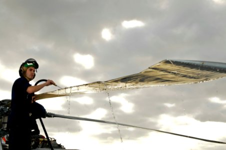 US Navy 111206-N-YM590-013 Aviation Structural Mechanic 2nd Class Kevin Barnett rinses a rotor blade of an SH-60B Sea Hawk helicopter