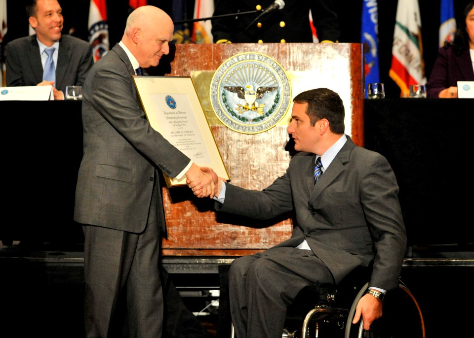 US Navy 111206-N-IL267-001 John Campbell, Deputy Assistant Secretary of Defense for Wounded Warrior Care and Transition Policy, presents Dr. Willia