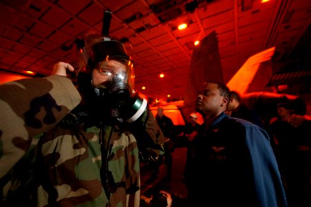 US Navy 111207-N-DR144-276 Airman Mikel Thompson is assisted by Logistics Specialist 2nd Class Arthur Simpson as he practices donning his MCU-2P p