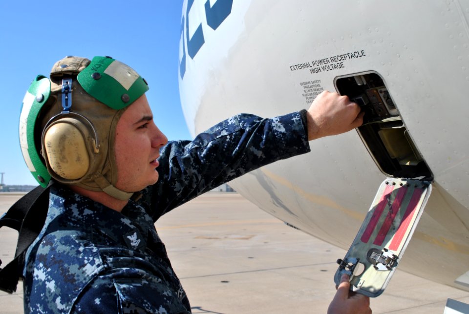 US Navy 111207-N-GO535-100 Aviation Machinist's Mate 2nd Class Ron Dischler inspects the ground power outlet of a C-9B Skytrain II aircraft