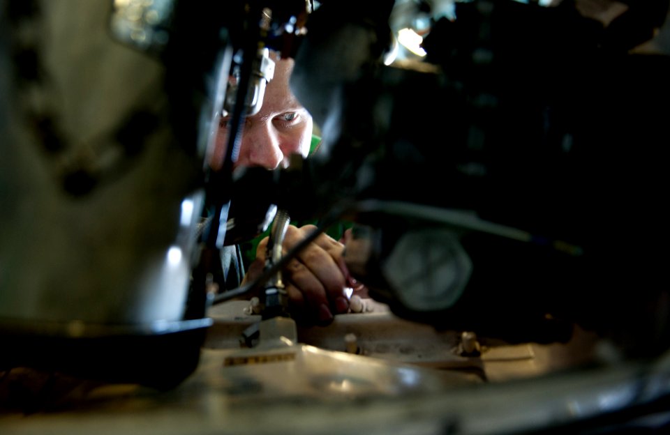 US Navy 111205-N-OY799-087 Aviation Structural Mechanic 3rd Class Allen Dedon drills out a stripped screw on an aerial refueling store from an F-A