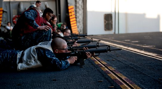 US Navy 111207-N-OY799-174 Sailors fire M-16 rifles during a small arms gun qualification on aircraft elevator three aboard the Nimitz-class aircra