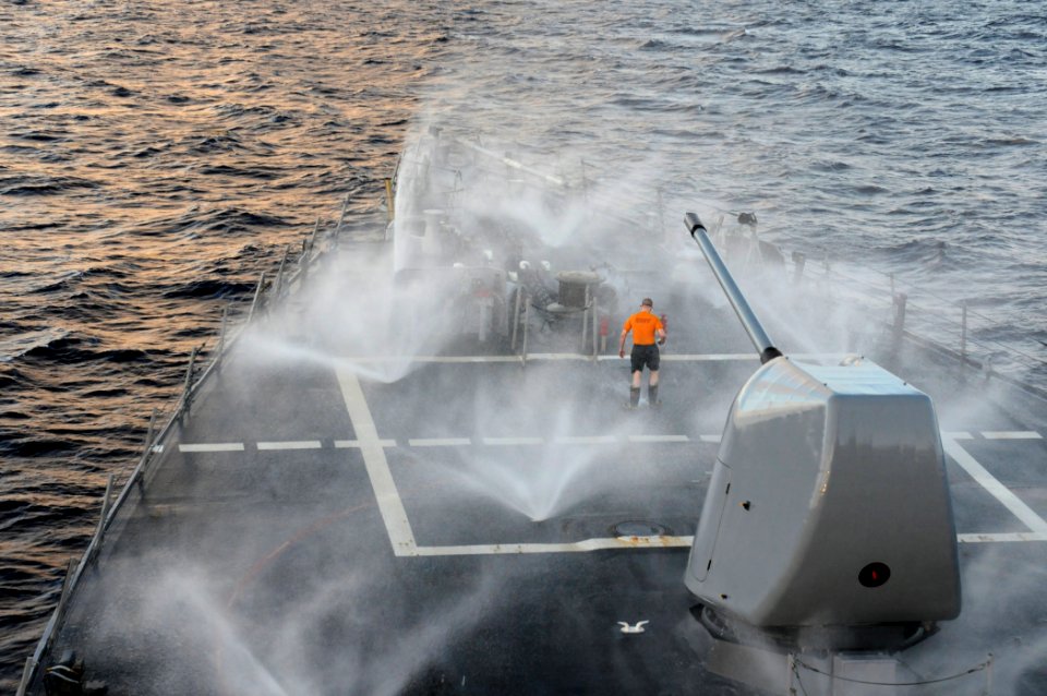 US Navy 111207-N-XQ375-012 Hull Maintenance Technician 2nd Class David Bowman walks near the bow of the guided-missile destroyer USS Mitscher (DDG