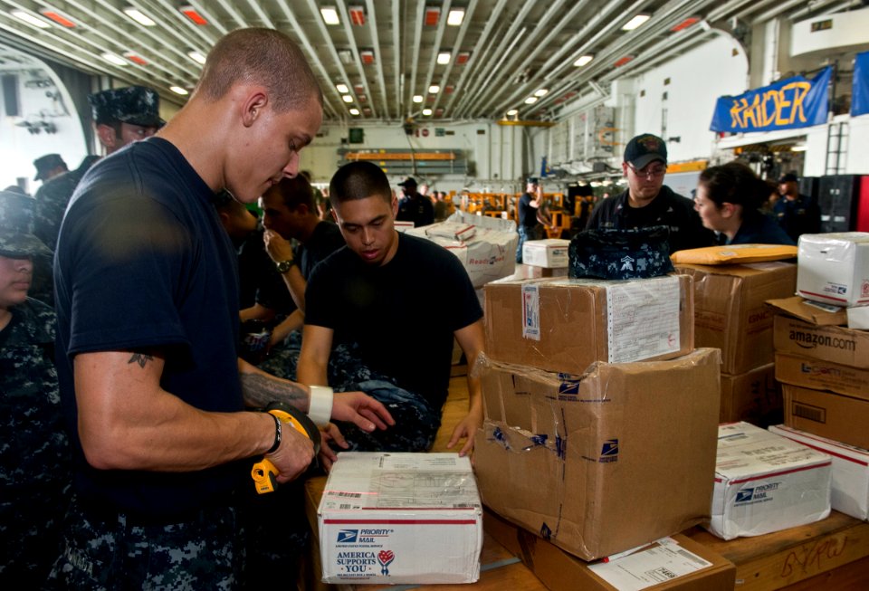 US Navy 111212-N-DX615-013 Logistics Specialist 3rd Class George Vonada scans mail aboard the amphibious assault ship USS Makin Island (LHD 8)