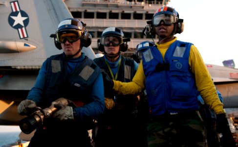 US Navy 111207-N-OY799-436 Sailors man a fire hose during drills on the flight deck of the Nimitz-class aircraft carrier USS John C. Stennis (CVN 7