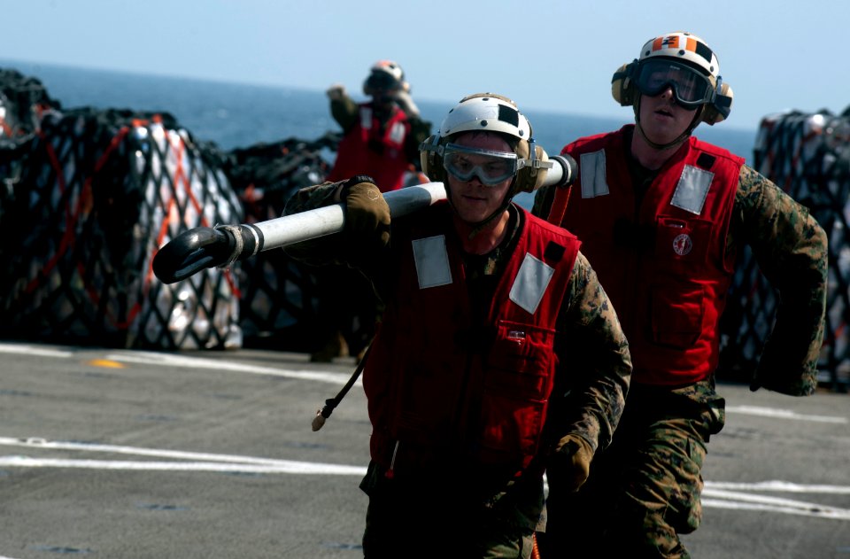 US Navy 111210-N-PB383-806 Marines assigned to the 11th Marine Expeditionary Unit (11th MEU) retrieve a cargo holder aboard the amphibious transpor