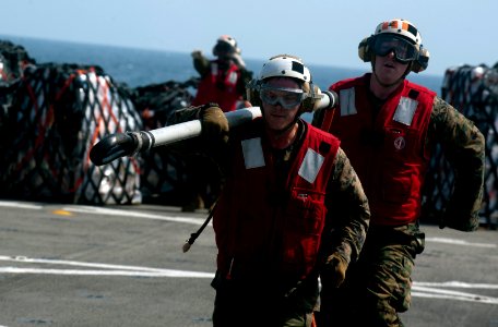 US Navy 111210-N-PB383-806 Marines assigned to the 11th Marine Expeditionary Unit (11th MEU) retrieve a cargo holder aboard the amphibious transpor