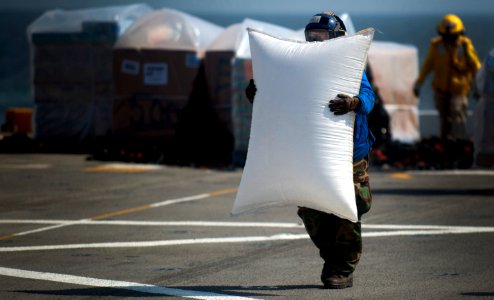 US Navy 111210-N-PB383-965 Aviation Boatswain's Mate Airman Sarah McGee carries packaging material on the flight deck of the amphibious transport d