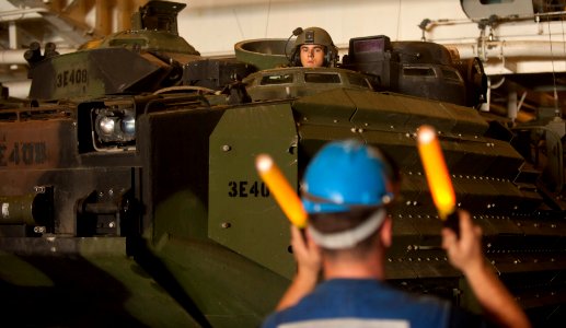 US Navy 111211-N-PB383-238 A Sailor guides an amphibious assault vehicle in the well deck of the amphibious transport dock ship