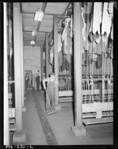 Wash and change house is swept by miner who formerly worked underground. Because of accident he is now working on the... - NARA - 540337