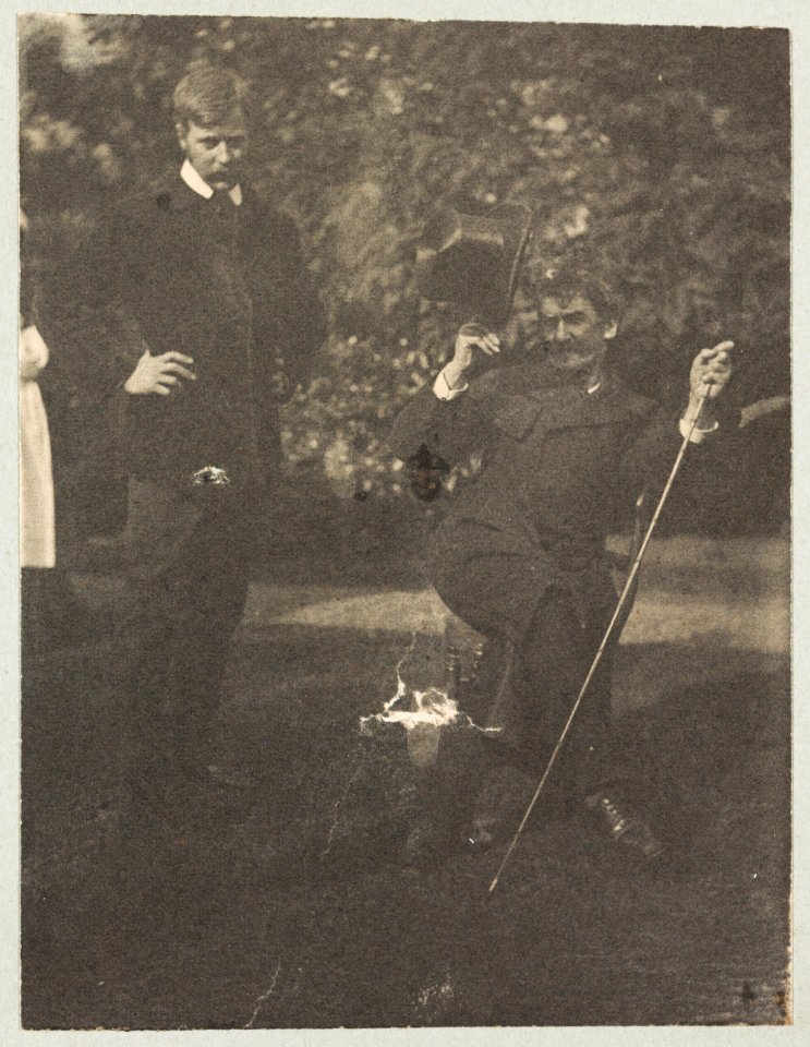 Whistler seated with Mortimer Menpes standing. Whistler wears the much talked about coat wth cape and curly brimmed hat LCCN2003688440