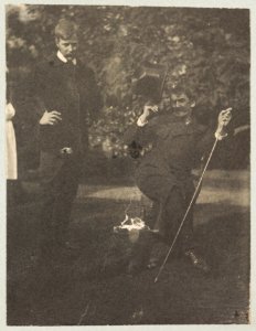Whistler seated with Mortimer Menpes standing. Whistler wears the much talked about coat wth cape and curly brimmed hat LCCN2003688440