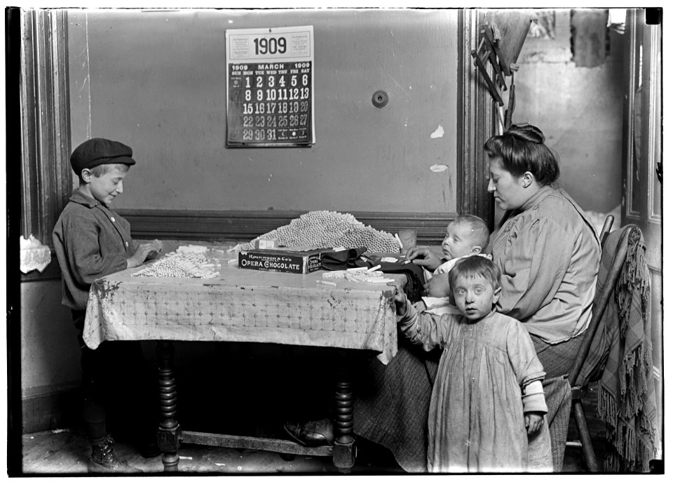 Widow & boy rolling papers for cigarettes in a dirty N.Y. tenement. LOC nclc.05349