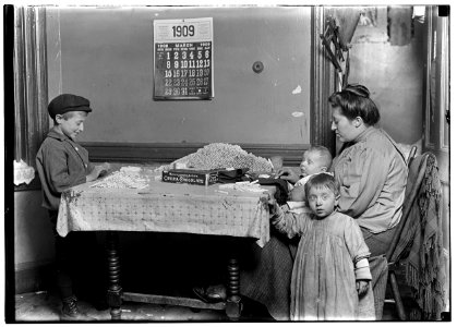 Widow & boy rolling papers for cigarettes in a dirty N.Y. tenement. LOC nclc.05349
