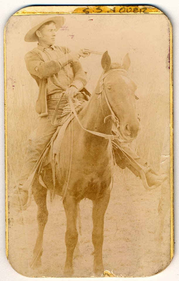 Will Roberts, alias Dixon, cowboy train robber, seated on a horse, pointing a gun LCCN2006680256
