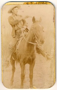 Will Roberts, alias Dixon, cowboy train robber, seated on a horse, pointing a gun LCCN2006680256
