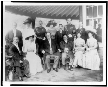 William H. Taft, seated on porch, with group of women and men LCCN96503584