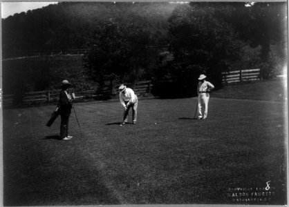 William H. Taft, full length, facing left, bending over to hit golf ball, with 2 other men on green LCCN2005697046