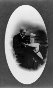 William Henry Werner, full-length portrait, seated, looking at a book with his grand daughter LCCN2005676619
