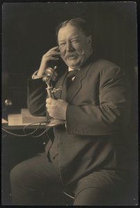 William Howard Taft, three-quarter-length portrait, seated, facing front, smiling while talking on a telephone as he receives news of his nomination as the 1908 Republican presidential LCCN2015647020