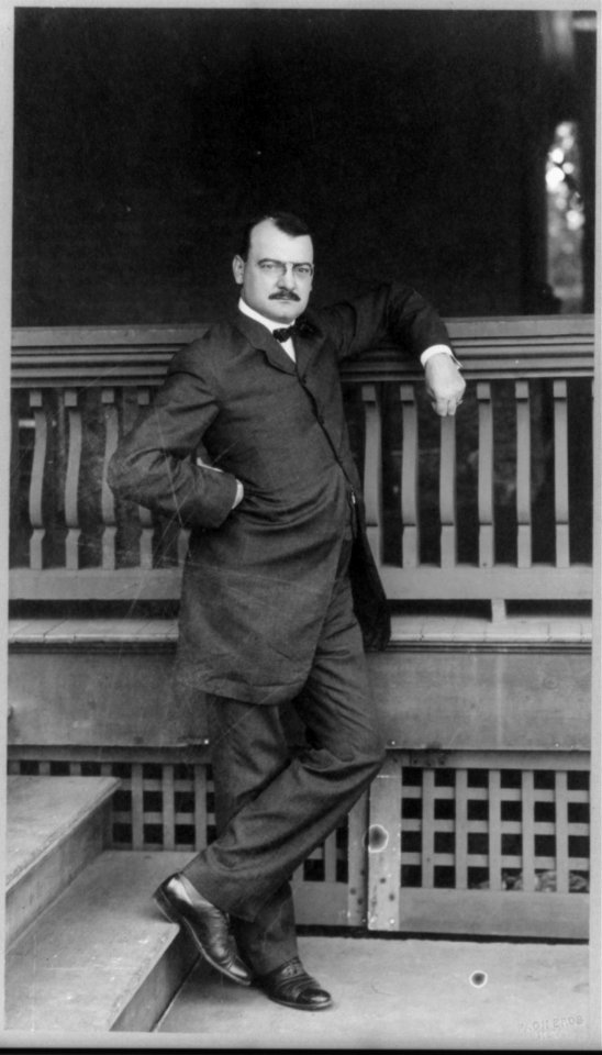 William Loeb, full-length portrait, standing, facing right, with left elbow on railing LCCN96503963