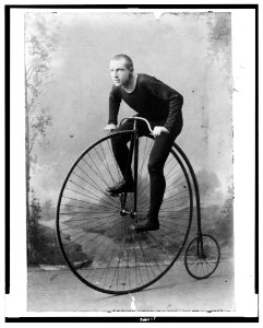William Martin, champion six-day bicycle rider of the world, full-length portrait, facing left, on bicycle with large front wheel and small rear wheel LCCN92508479