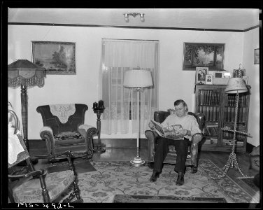 William Morrison, miner, sitting in living room of his home in company housing project. Pikes Peak Fuel Company, Pike... - NARA - 540445