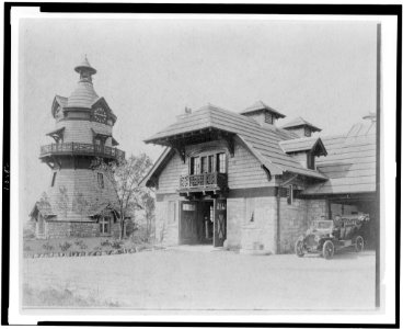 Windmill-shaped clock tower at left, and part of garage of Edmund Cogswell Converse, with two men on automobile at right, Greenwich, Connecticut LCCN94502486 photo