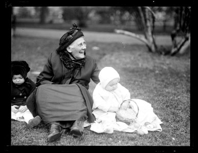 Woman and child with easter basket seated on grass LCCN2016891363