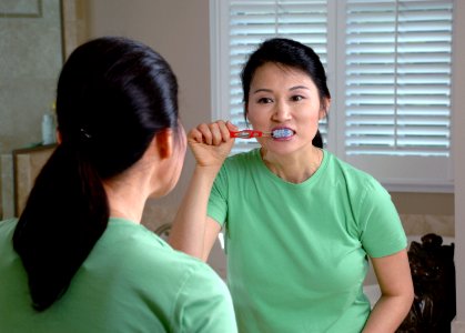 Woman brushing teeth photo